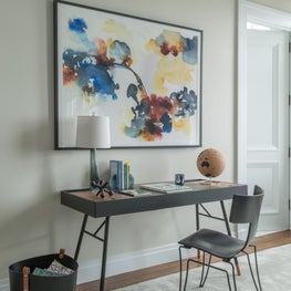 Sleek, modern NYC home office with colorful artwork and accessories 