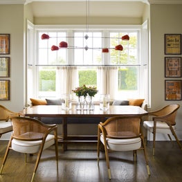 Sagaponack dining nook with woven back chairs and modern, red chandelier