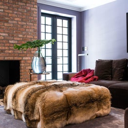 Family Room with brick fireplace, purple walls, and cement floor tiles 