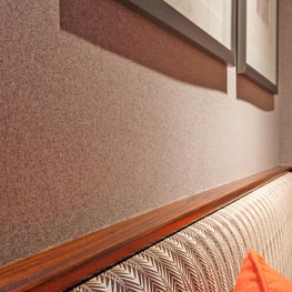 Grey flannel walls in bar w/ custom zebra upholstered bench by Sophia Shibles