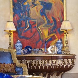 In a remodelled Dallas, TX greatroom, custom furniture pieces are mixed with dramatic modern art and vivid art glass accessories