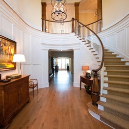 Painted Paneled Foyer with Turned Walnut Newel Post and Curved Stair