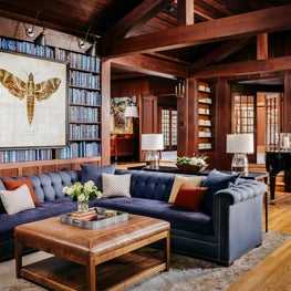 Craftsman family room and library with bookcase, leather ottoman, blue sectional