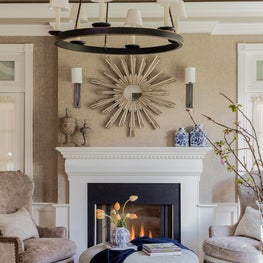 Neutral beige cream living room sunburst round ottoman two-tier chandelier