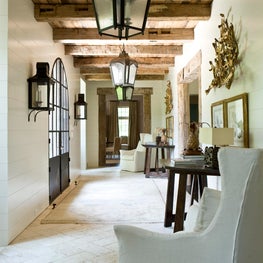 Authentic foyer and hallway with tile floor and high, beamed ceilings
