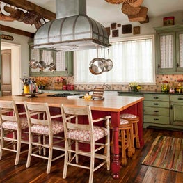 Country French kitchen with colorful cabinets and custom zinc vent hood