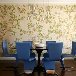 Dining area with topiary wallpaper and Art Deco blue chairs