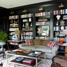 An eclectic seating area with a wall of shelves