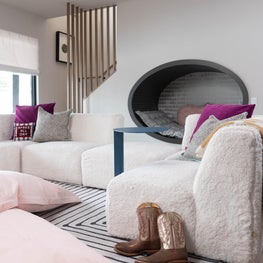 Chic, cozy, and complete with an under the stairs reading nook, this kiddos lounge is ready for endless after-school fun.