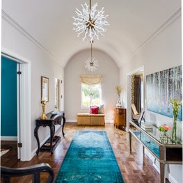 Entry hall foyer with transitional lighting, teal antique rug, mirrored console