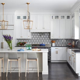 White kitchen with black flooring, gold and brass accents