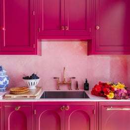 Custom Kitchen Cabinets in berry with arch detail, pink marble, & brass fixtures