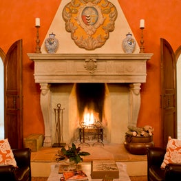 Curved ceilings, a rich color palette and grand fireplace create an inviting space.