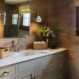 Warm modern farmhouse bathroom with brass accents, warm brown wallpaper