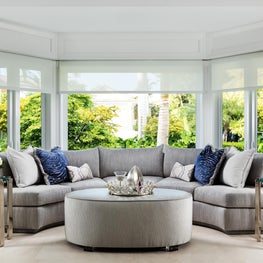 Curved light grey upholstery sofa in this contemporary light infused family room.