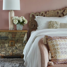 Elegant layering in this dusty pink, boho chic master bedroom