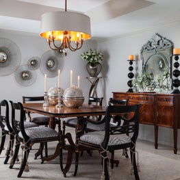 A grey backdrop is enhanced by an ornate antique mirror and walnut buffet.