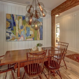 Vintage dining set with modern lighting and art create a dynamic mix.