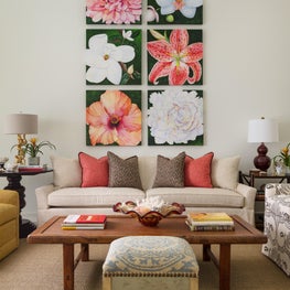 Floral artwork adorns this neutral living room with pops of colored accents.