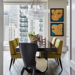 A dining room with a visual feast of color, hammered iron chairs, and bold art. 