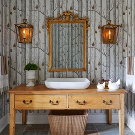 Three Barn Farm Bathroom. Rustic chic bathroom with tree print wallpaper, lantern sconces & wood vanity.