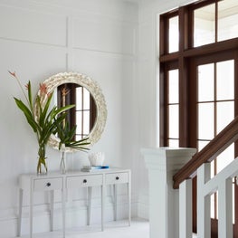White minimal entry with contrasting dark wood trim.