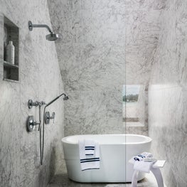  A state-of-the-art bathroom with glass enclosed shower and a freestanding tub.