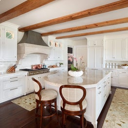White Kitchen with Stone Hood and Natural Beams
