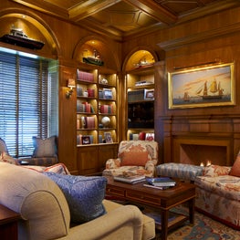 A fully paneled library with a nautical theme.