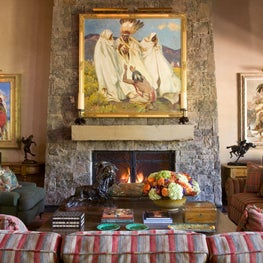 Large stone firplace with collection of nature American art.