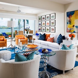 This neutral living room has pops of orange and blues like the ocean.