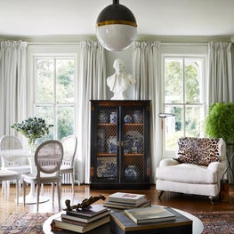 Hudson Valley Style / An eclectic combination of antiques and interesting objects enliven this lovely white parlor. A neoclassic bookshelf exhibits a collection of blue and white china.