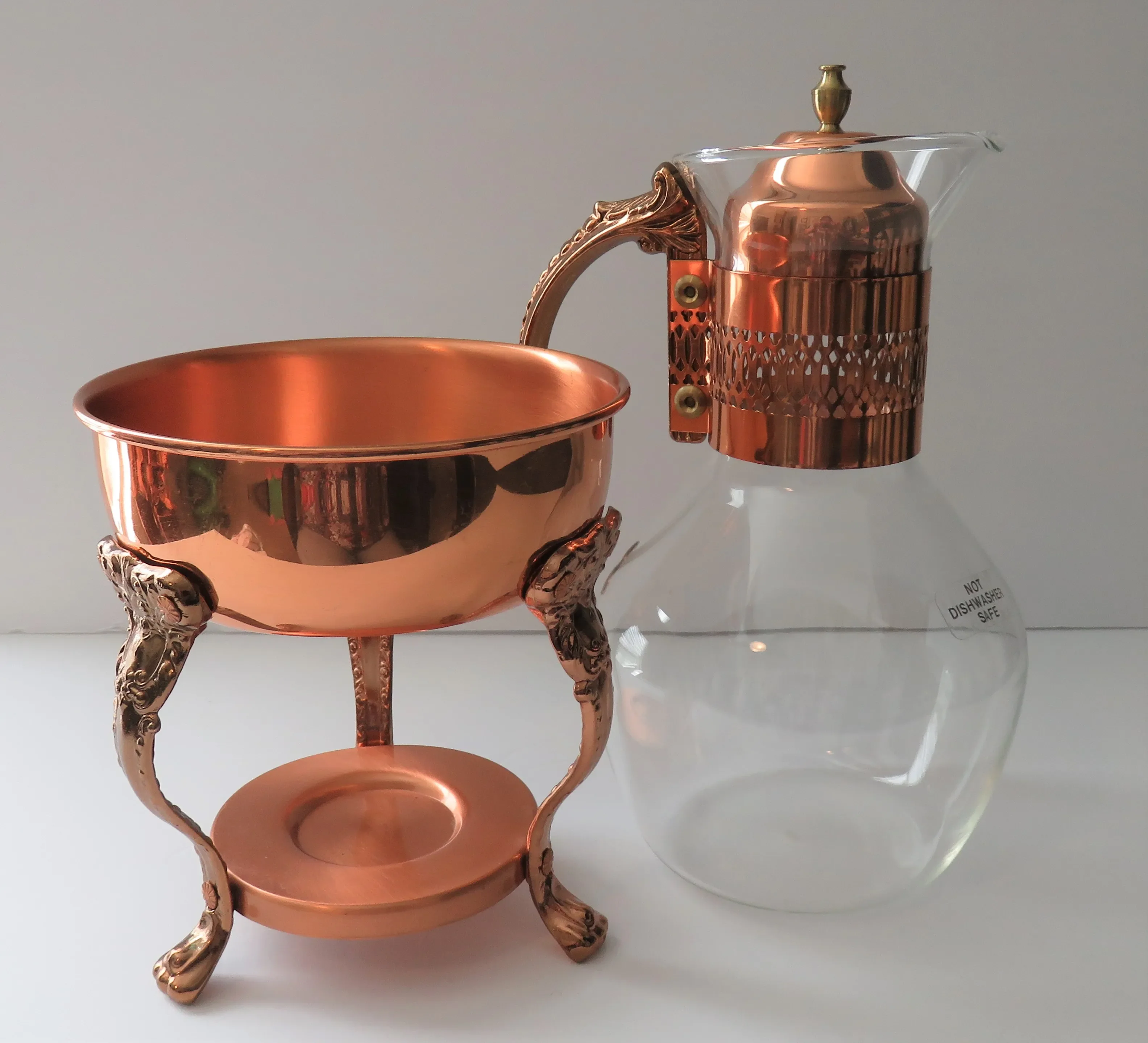 https://chairish-prod.freetls.fastly.net/image/product/master/71ad6bc8-72d7-44cf-a2a1-3a812e3688d8/vintage-princess-house-copper-coffee-tea-pot-carafe-warming-stand-with-lid-5473