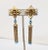 1960s goldtone open work square-ish top with faux-turquoise cabcohonfs and beads with tassel bottom with more small faux-...