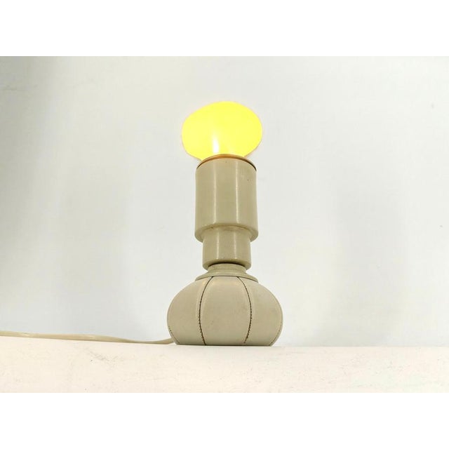 Rare mid century table lamp designed by gino Sarfatti and produced by Arteluce. Its made from aluminum and a leather...