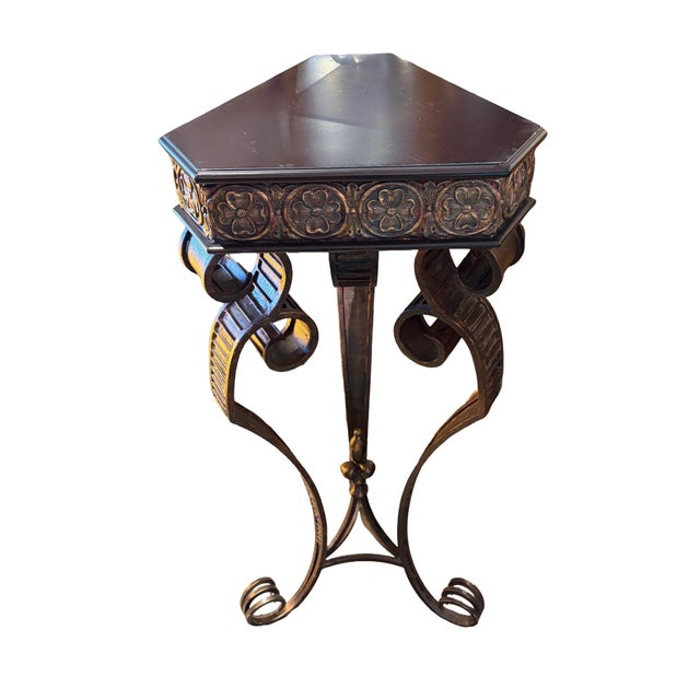 Triangular top side table featuring a dark wood top with relief floral/rosette carved aprons, supported by a tripod...
