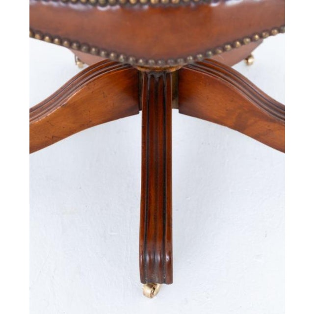 A handsome and substantial antique swivel desk chair of exceptional quality, raised on a finely crafted mahogany base with...