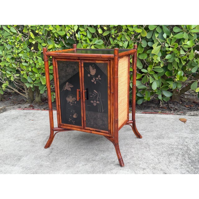 A beautifully crafted Palecek accent cabinet featuring a natural bamboo frame, hand-painted front door panels with Asian-...