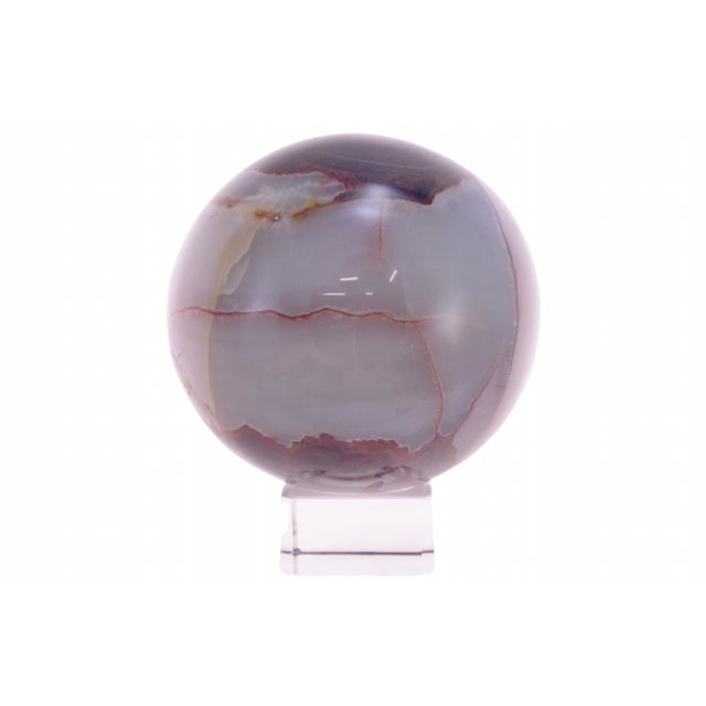Large natural three inch agate marble ball carved and polished to accent the striations of white, brown and gold on glass...