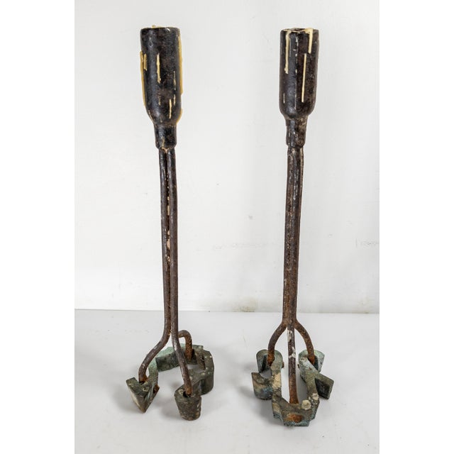 We are selling this cool pair of Candlesticks. These wrought iron candlesticks have bases that are old or vintage cattle...