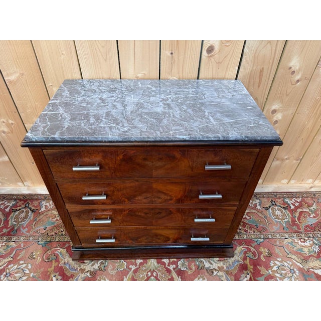 Art Deco four-drawer commode, circa 1930, in solid walnut and burr walnut veneer with a book-matched, symmetrical...