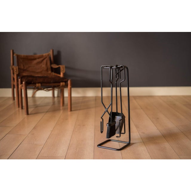 Vintage 4-piece fireplace tool set made of cast and wrought iron, circa 1970s. This unique set features a sculptural...