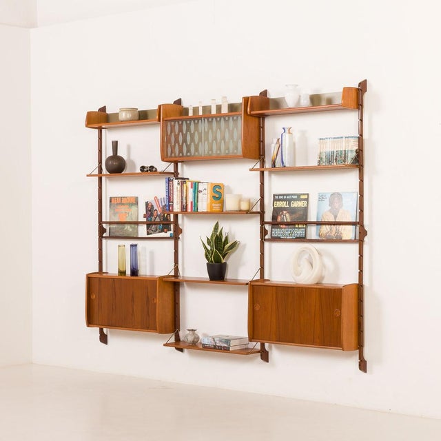 This fully renovated scandinavian three-bay wall unit in teak comes from norway from the 1960s. It is a completely modular...