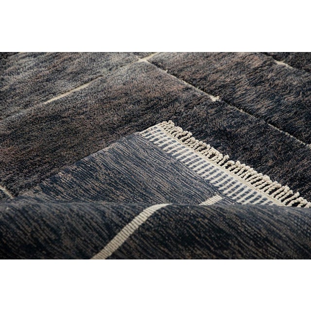 A study in structure and depth, woven line by line. This striking rug unfolds a refined grid pattern across its surface,...