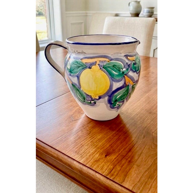 The image showcases a beautiful, handcrafted ceramic pitcher, from Sicily, Italy. The following information is known:...