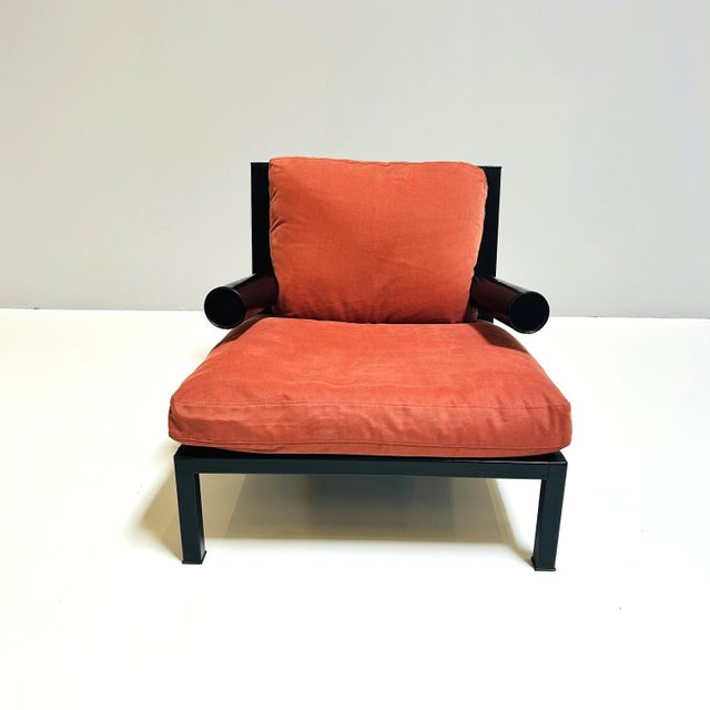 Baisity' armchair by Antonio Citterio for B&B with red fabric cushions. Metal frame covered in black leather. This piece...