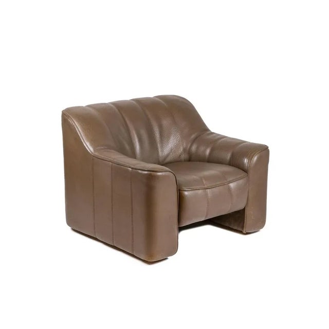 Armchair and ottoman in grooved leather, glossy brown color. Large armchair with its sliding seat. Square or cube shaped...