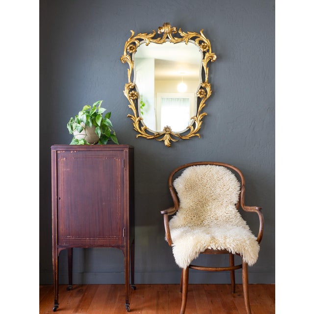This oversized gilded gold leaf Italian toleware mirror features scrolling foliage and rosettes of dramatic scale and...