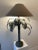 A handcrafted 1985 Sarreid Ltd. metal palm tree lamp featuring layered fronds and an embossed stepped base. Made from...