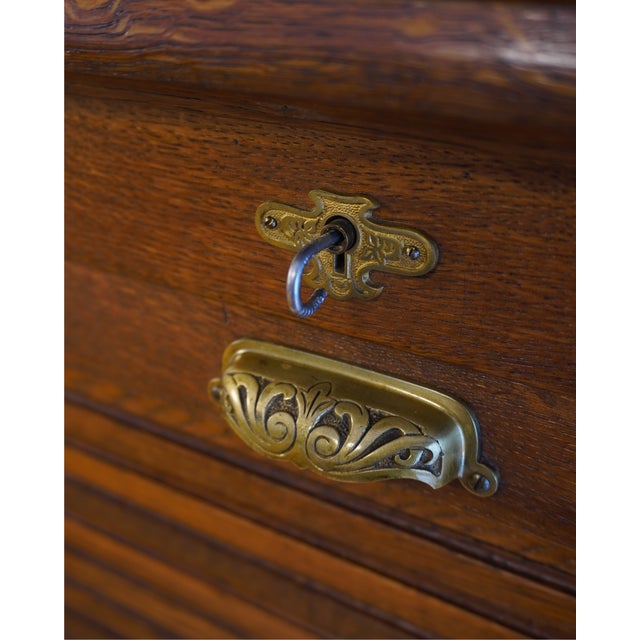 This remarkable roll-top desk embodies all the charm and functionality of antique office furniture. Crafted primarily from...